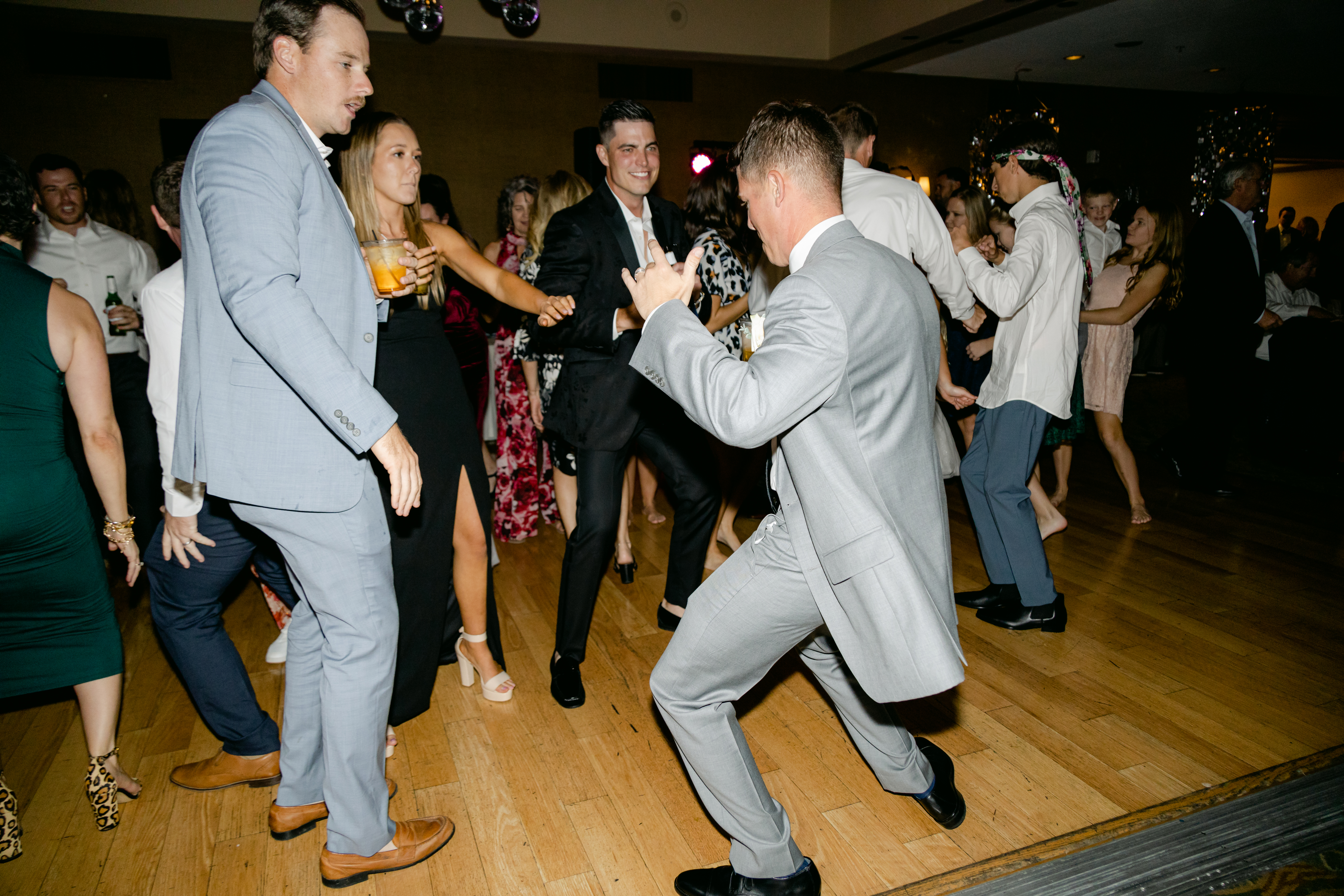 Guest in a red satin dress laughing on the dance floor