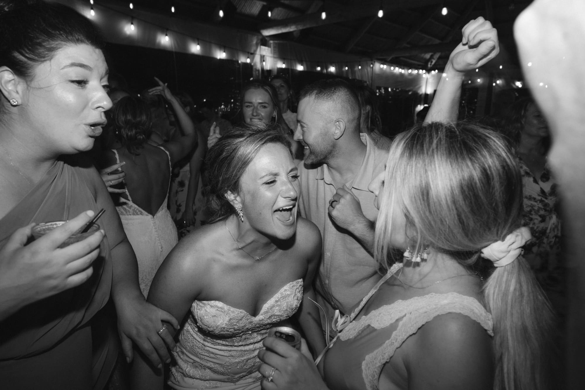 Black and white candid of bride laughing with friends