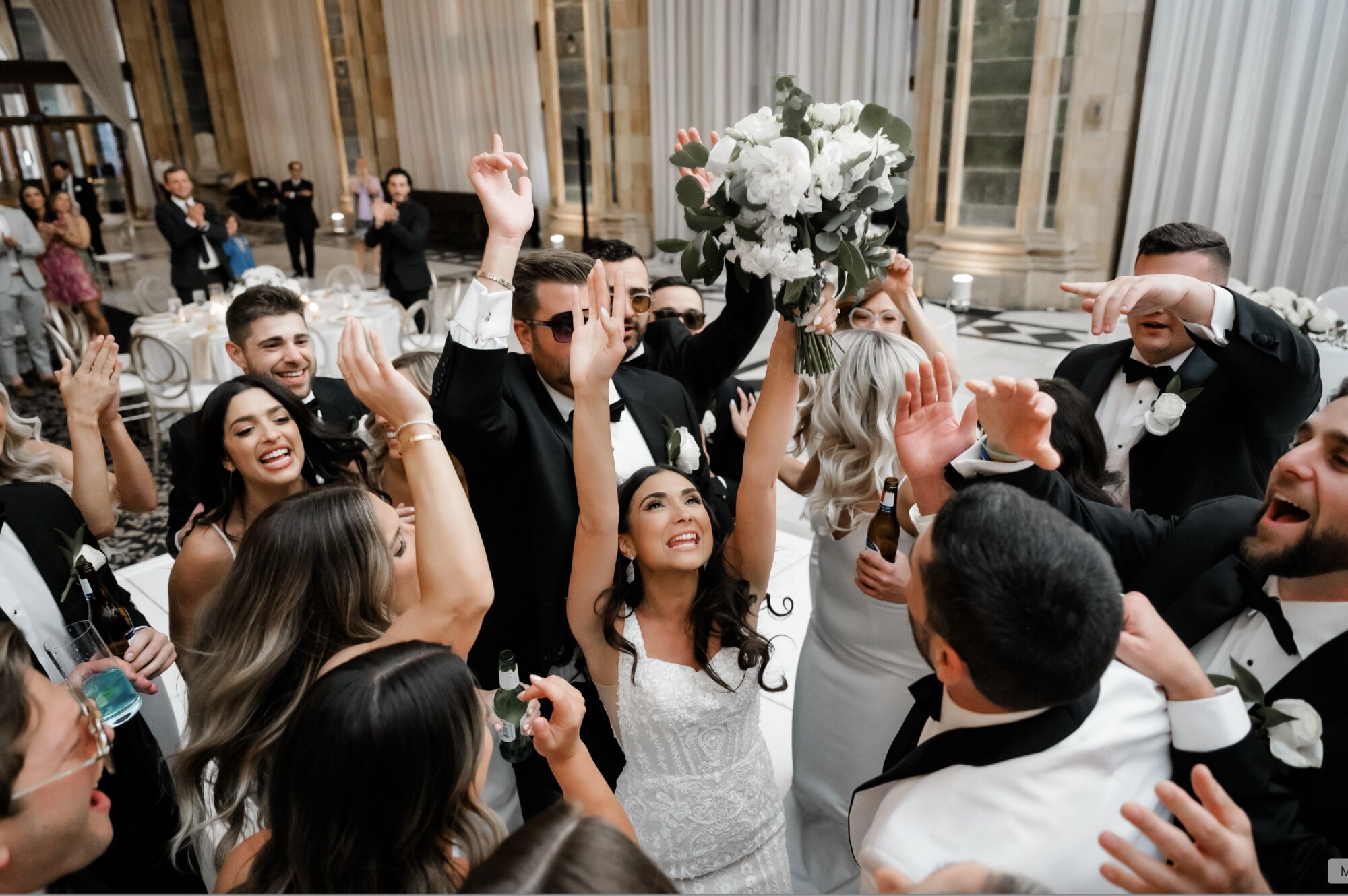 Bride tossing her bouquet surrounded by cheering guests